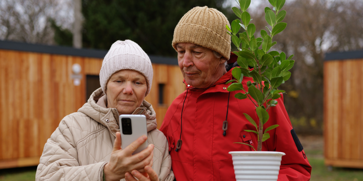 Two gardeners looking at a plant disease on their phone together